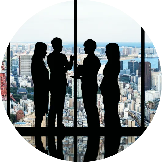 高層ビルの窓辺で談話する四人の影