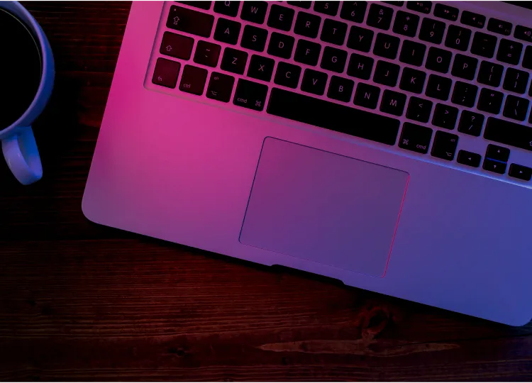 ピンクのライトに照らされたノートPC